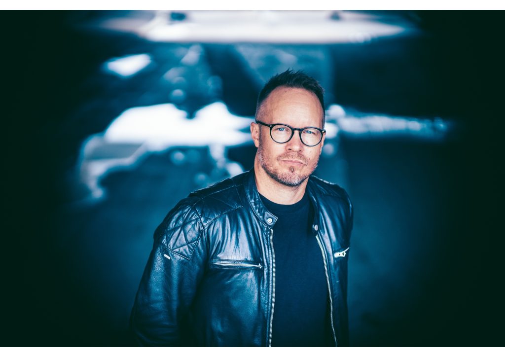 Kirjailija Matti Laine poseeraa tummanpuhuvassa kuvassa