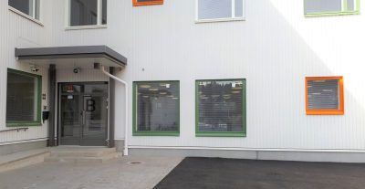 Riistaveden kirjaston vaaleaa julkisivua värikkäine ikkunanpielineen.